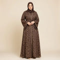 Woman wearing a brown patterned abaya and hijab on a beige background