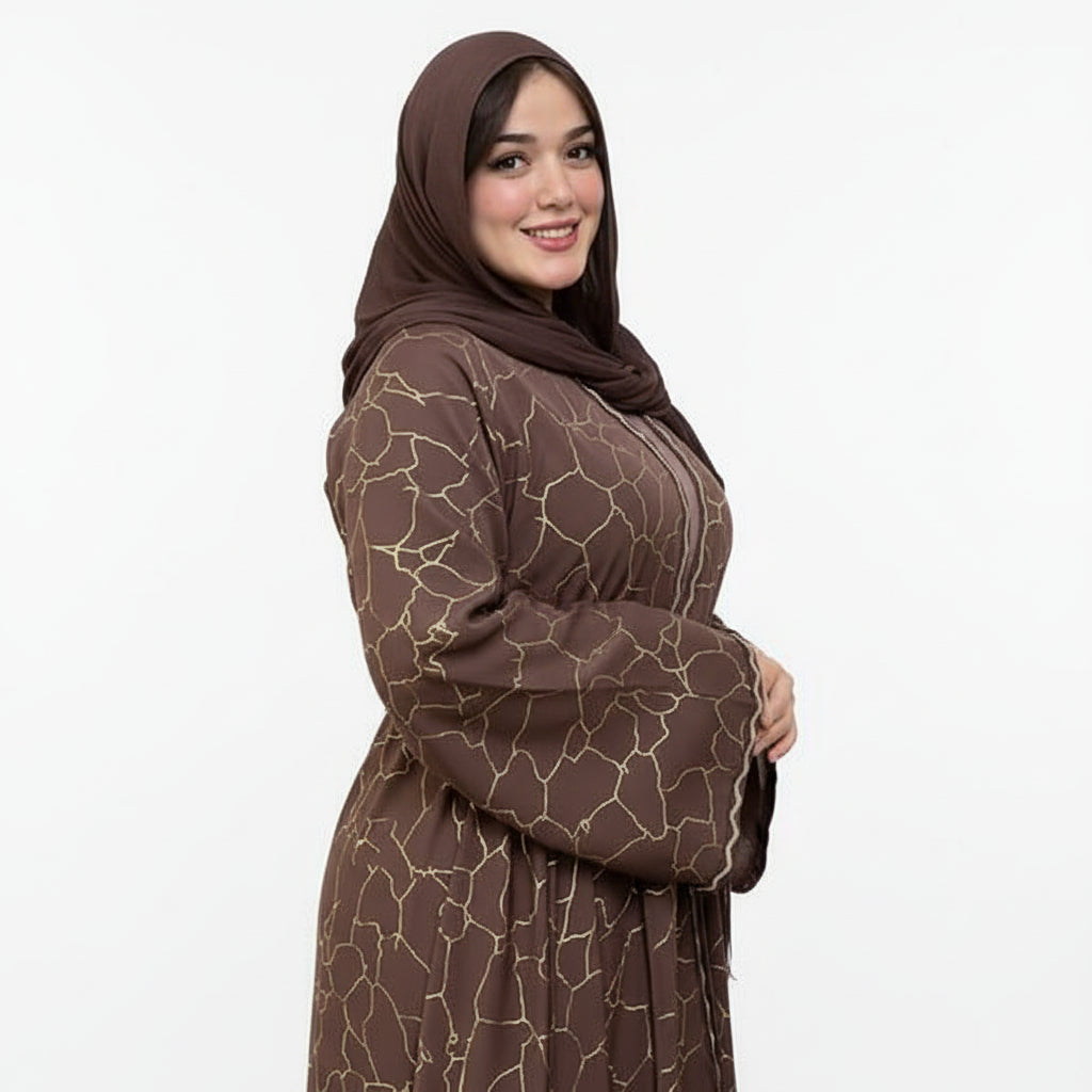 Woman wearing a brown patterned outfit and hijab standing outdoors.