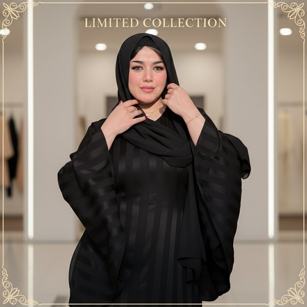 Woman wearing a black abaya outdoors with greenery in the background